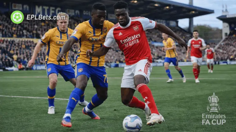 Mansfield and Arsenal players tussle for the ball