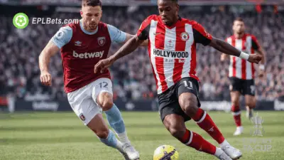 A Brentford player holds off a West Ham player