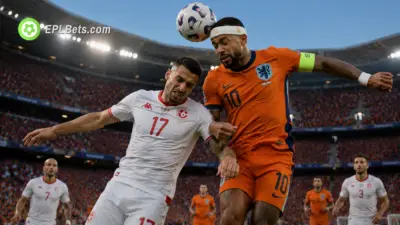 Memphis Depay of Netherlands and Ellyes Skhiri of Tunisia challenge for an aerial ball in their Group F match