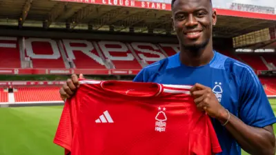 Nottingham Forest new signing Ousmane Diomande holds a Forest shirt