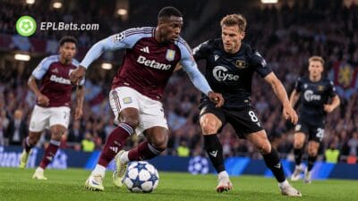 Aston Villa striker Nicolas Jackson dribbles forward in a claret and blue home kit as a Viking FK defender challenges him during a Champions League match illustration at Villa Park.