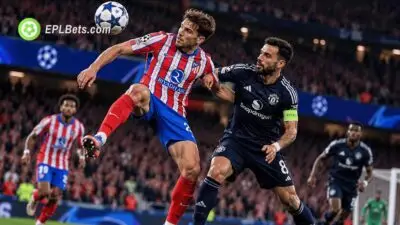 An Atletico Madrid player controls an aerial ball while Manchester United captain Bruno Fernandes challenges for possession during a Champions League clash.