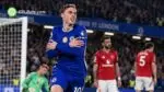 Chelsea midfielder Cole Palmer celebrates a goal with his trademark crossed-arms celebration as Manchester United players look dejected at Stamford Bridge.
