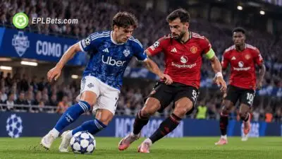 Como midfielder Nico Paz dribbles with the ball as Manchester United captain Bruno Fernandes challenges him during a Champions League match illustration.