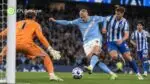 Erling Haaland prepares to shoot for Manchester City as a Brighton defender challenges him inside the penalty area.