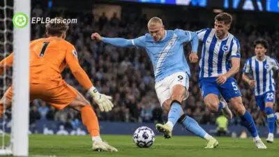 Erling Haaland se prepara para chutar pelo Manchester City enquanto um zagueiro do Brighton o marca dentro da área.