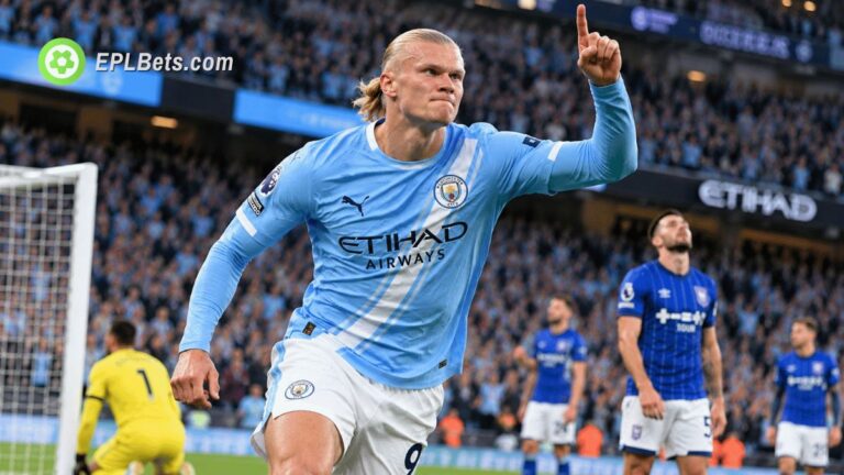Erling Haaland comemora com o dedo levantado, vestindo a camisa do Manchester City, com os jogadores do Ipswich Town ao fundo.