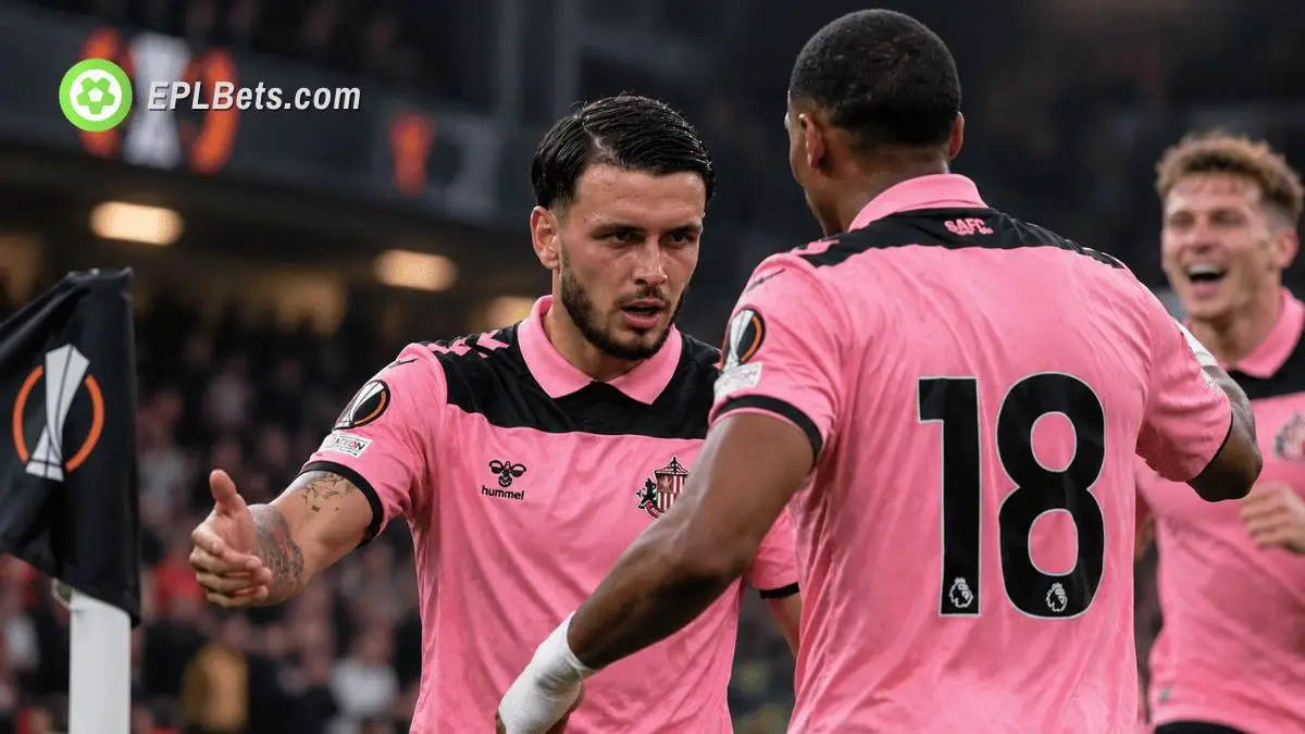 Sunderland midfielder Enzo Le Fée celebrates with teammates in the club's pink away kit beside a UEFA Europa League corner flag.