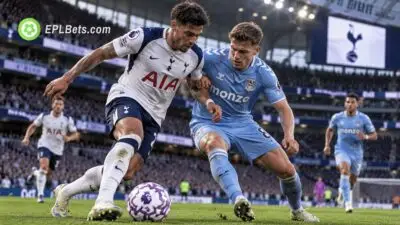 Tottenham Hotspur player in a white home shirt shields the ball from a Coventry City player wearing sky blue during a Premier League match illustration.